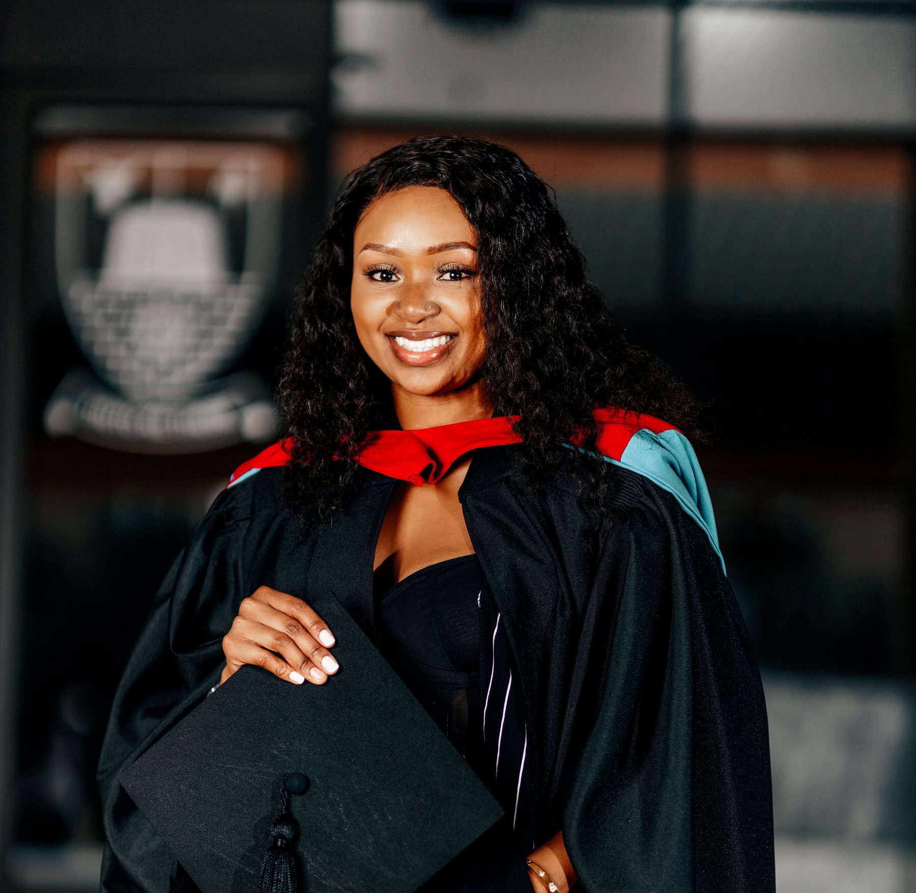 Graduate holding mortarboard at graduation ceremony