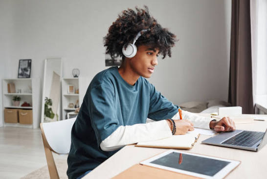 Teenage student studying with headphones, ages 12 to 18