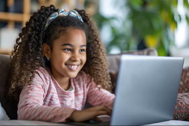 Young girl learning on laptop, ages 4 to 9